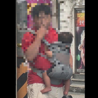 아기를 안고 길거리에서 담배를 피우는 남성의 모습이 공개돼 온라인에서 거센 비판을 받고 있다./사진=온라인 커뮤니티 화면 갈무리.
