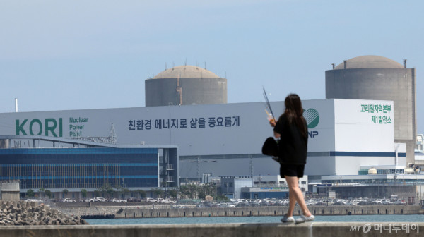 부산 기장군이 0.7GW급 국내 첫 소형모듈원자로(SMR) 1기의 건설 후보지로 선정된 가운데 18일 기장군의 한 방파제를 지나는 시민 뒤로 고리원전 1~2호기가 보이고 있다. 2026.06.18. /사진=뉴시스