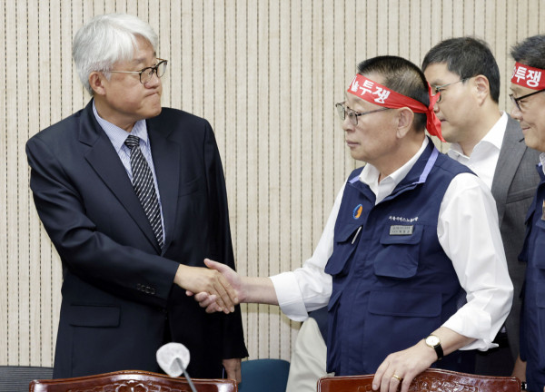 김정환(왼쪽) 서울시버스운송사업조합 이사장과 박점곤 전국자동차노동조합연맹 서울시버스노동조합 위원장이 지난 15일 서울 영등포구 서울지방노동위원회에서 열린 서울시내버스 노사 2차조정회의에서 악수하고 있다./사진=뉴시스 